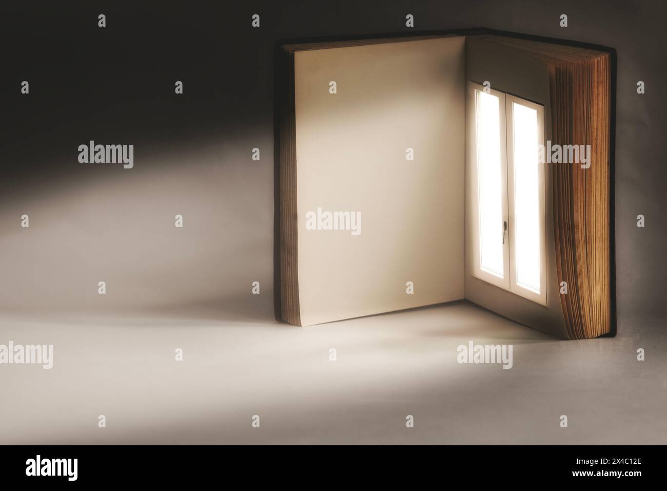 libro aperto con una finestra illuminata surreale su una pagina, concetto astratto Foto Stock