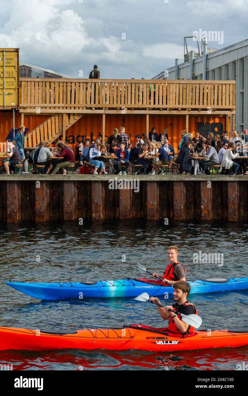 Copenhagen, Danimarca, grande folla di persone, condivisione di bevande al bar locale "Papiroen" sul fiume, kayak maschile Foto Stock