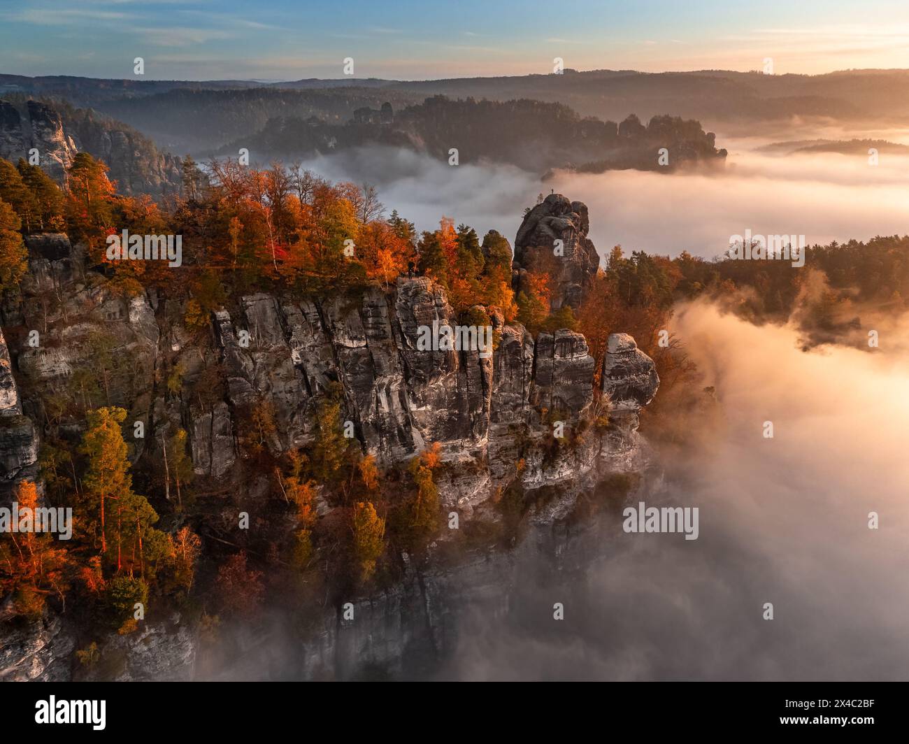 Sassone, Germania - Vista aerea del Bastei in una nebbiosa mattina autunnale con colorate foglie autunnali e fitta nebbia sotto la roccia. Bastei è una forma rock Foto Stock