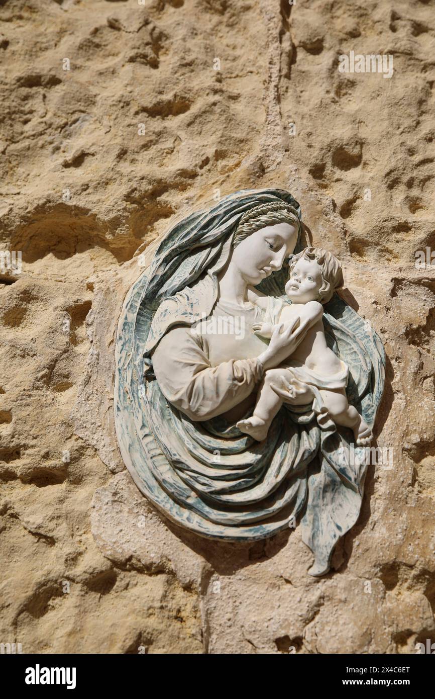 La Valletta, Malta. Icona religiosa affresco di una madre e di un bambino in pietra calcarea nella città murata Foto Stock