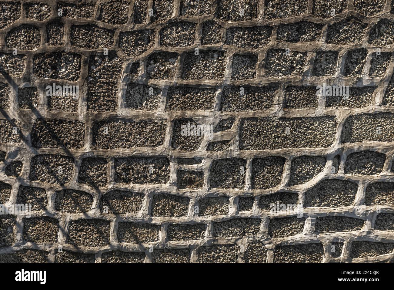 Un muro in pietra con bordi in cemento sporgenti Foto Stock