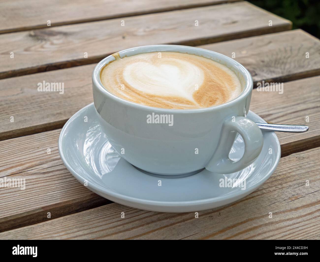 Primo piano di una tazza di latte su un tavolo di legno Foto Stock