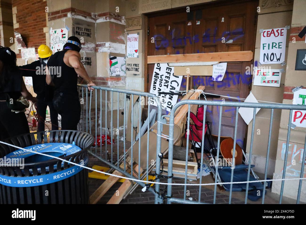 â maggio 2024, Los Angeles, California, Stati Uniti: Un cartello intonacato alla porta che è stato barricato per tenere fuori la polizia legge, œYou non può sconfiggere le persone che non hanno paura di dieâ€ presso il campus di Westwood dell'Università della California, Los Angeles (UCLA) il maggio 2024: i manifestanti pro-Palestina/Hamas nel loro accampamento tenda vandalizzano Royce Hall, un edificio musicale scolastico, poche ore prima che la polizia lo razziasse e facesse degli arresti. Un altro segno dice, â€œIranian Palestineâ€, e â€Œland devi uccidere non è tuo: itâ€™S 4 Palestine.â€ Un segno di riciclo è in primo piano. (Immagine di credito: © Amy Katz/Z Foto Stock