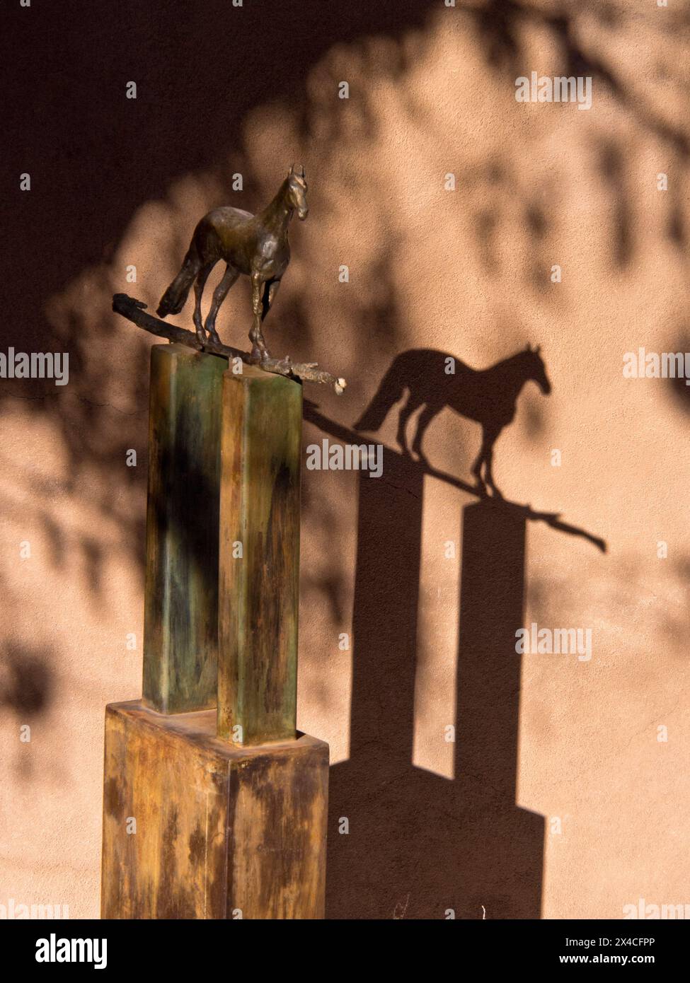 Stati Uniti, nuovo Messico, Sante Fe. Statua di bronzo di un cavallo su una tribuna di metallo e un'ombra sul muro. (Solo per uso editoriale) Foto Stock