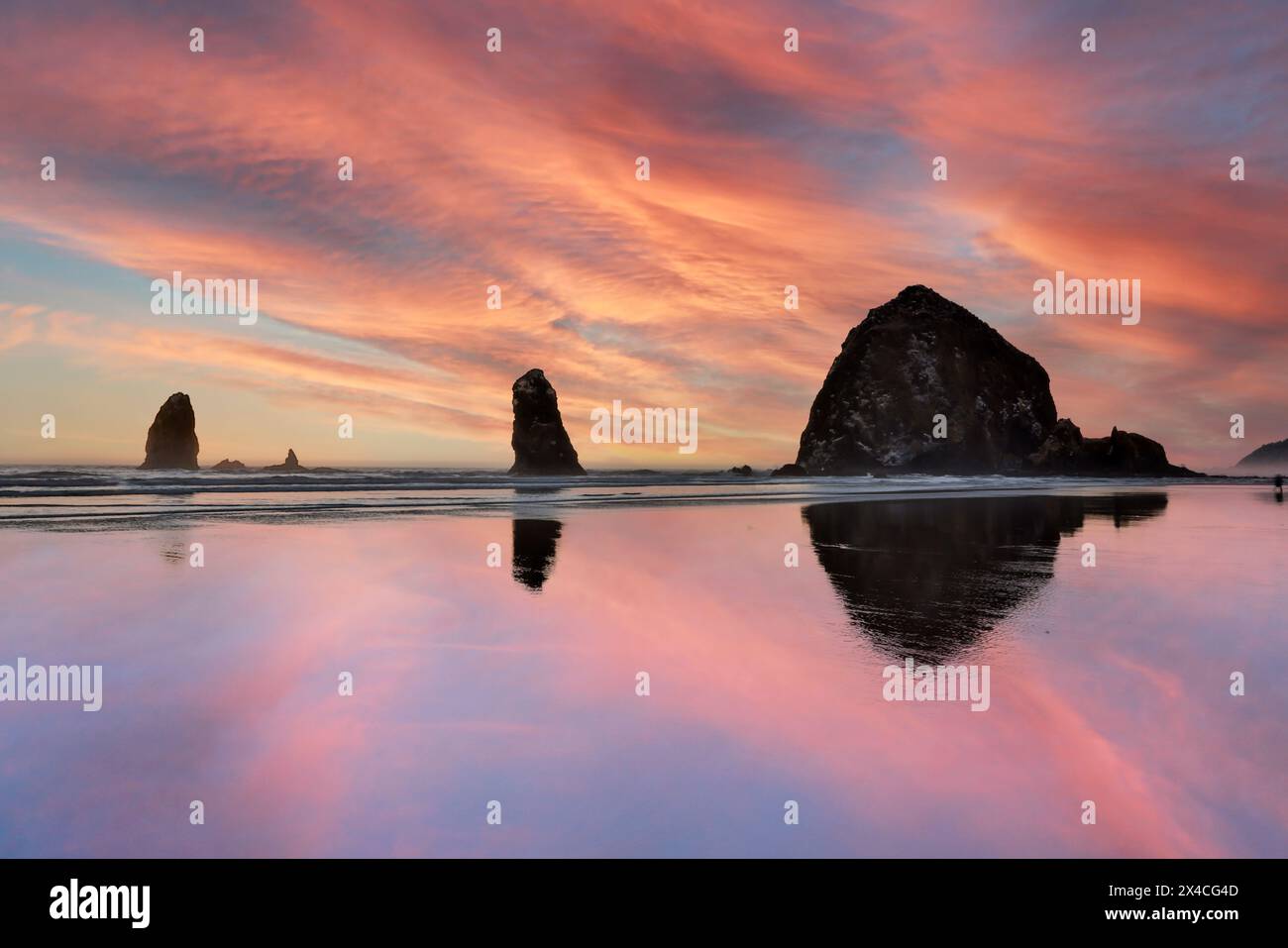 Stati Uniti, Oregon. Cannon Beach e Haystack Rock al tramonto e durante la bassa marea Foto Stock
