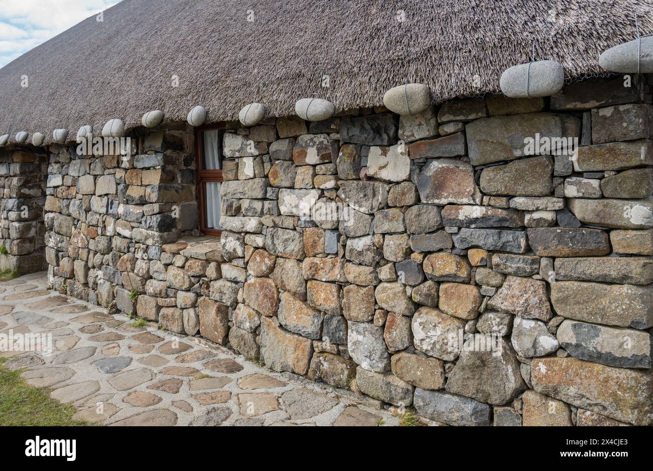 Cottage tradizionali di crofters realizzati in pietra locale e canne per tetti di paglia al museo Skye della vita sull'isola, Isola di Skye, Scozia. Foto Stock