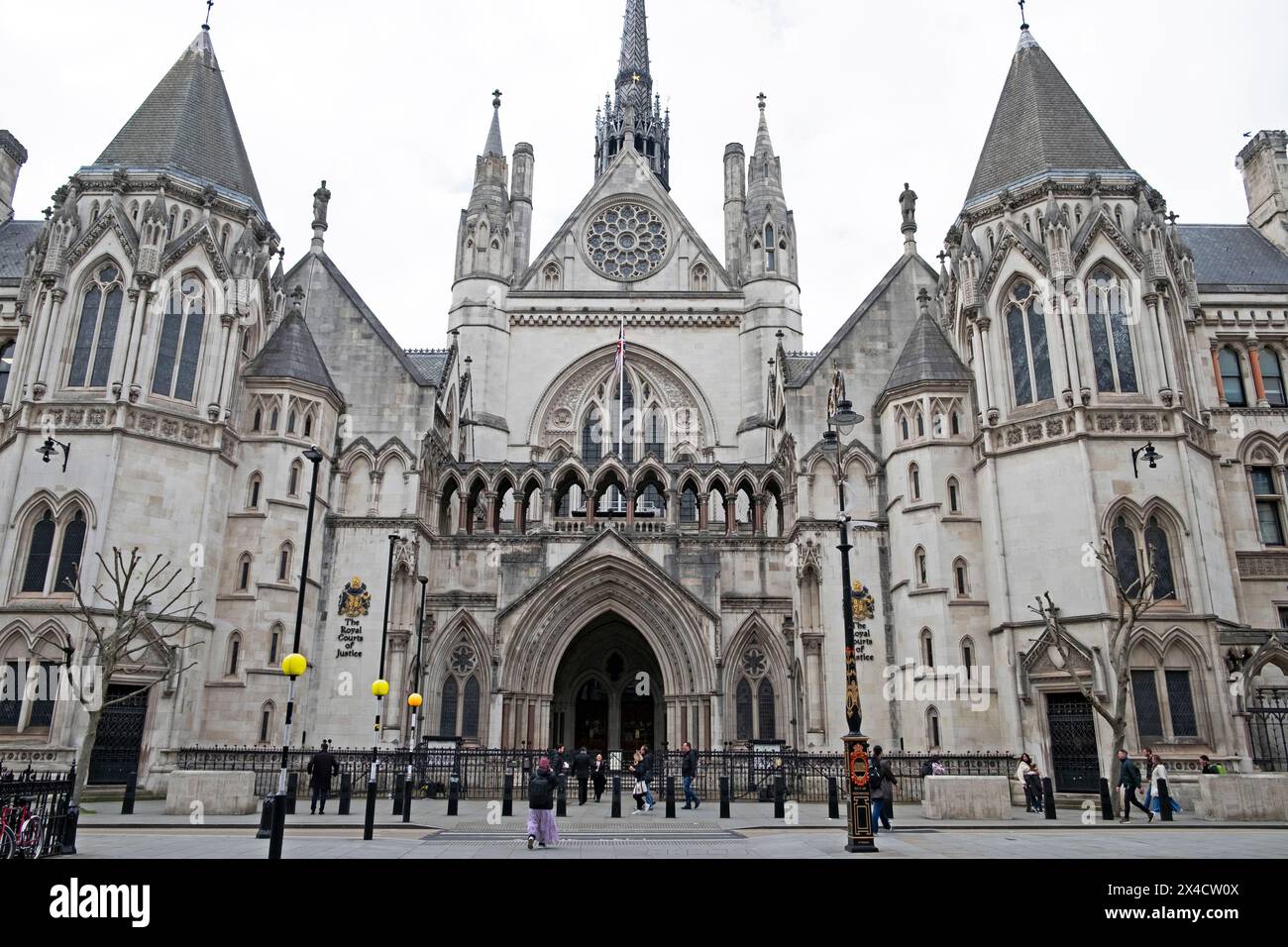 Vista esterna persone sulla strada facciata dell'edificio Royal Courts of Justice sullo Strand nella City di Westminster Londra Regno Unito KATHY DEWITT Foto Stock