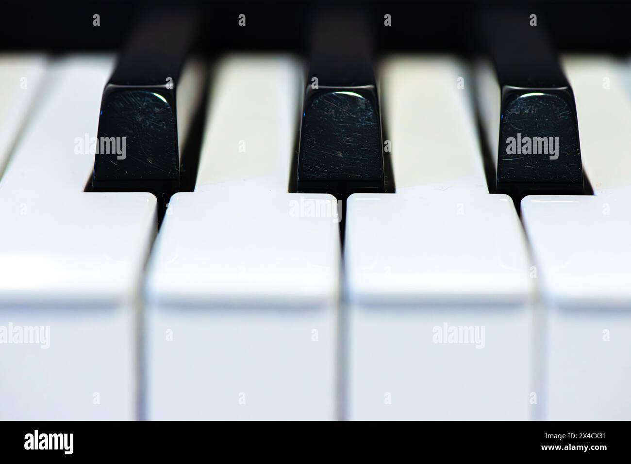 Una foto macro ipnotizzante cattura i dettagli intricati e il contrasto dei tasti del pianoforte in bianco e nero, evidenziando l'essenza dell'arte musicale. Foto Stock