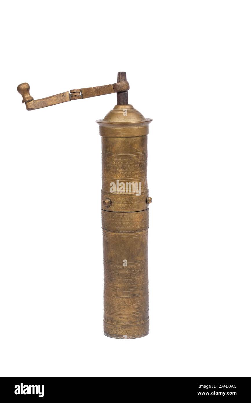 Mulino in ottone dorato mediorientale con incisione ornata - tradizione culinaria su sfondo bianco Foto Stock