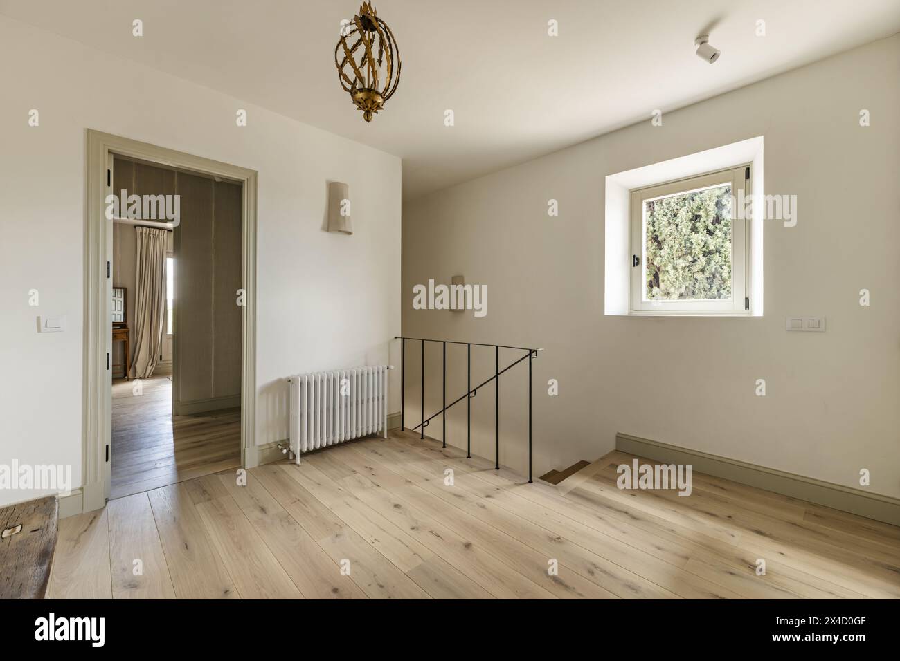 Scala in legno di una casa singola con ringhiera in metallo di stile minimalista, finestra quadrata in alluminio e accesso ad una camera da letto con anticamera Foto Stock