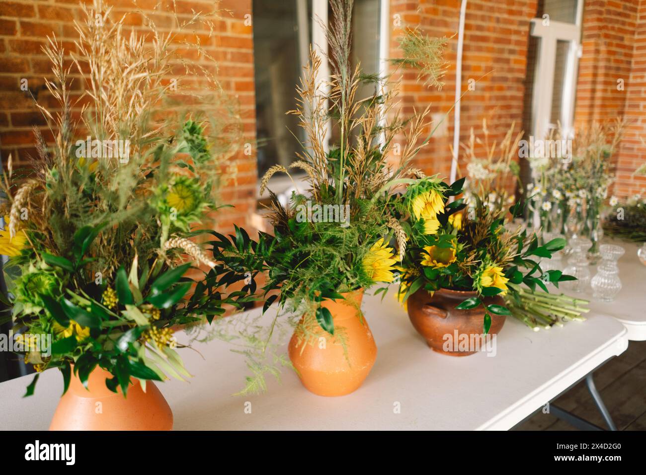 Eleganti centenari Wildflower che adornano un tavolo festivo durante un evento al coperto di un lungo tavolo Foto Stock