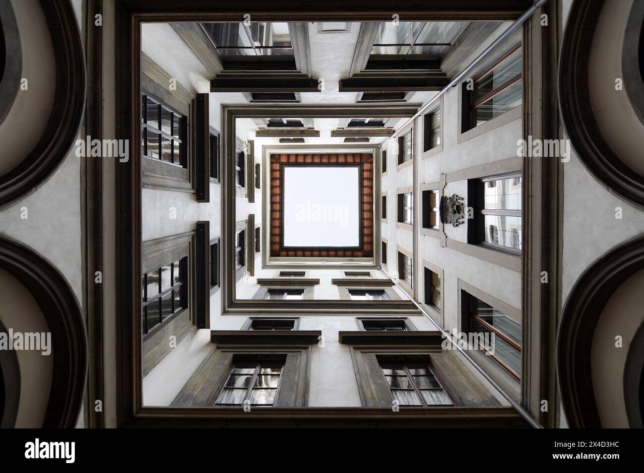 Una vista all'interno di un patio quadrato all'interno di un isolato a Firenze, in Italia, guardando in alto Foto Stock