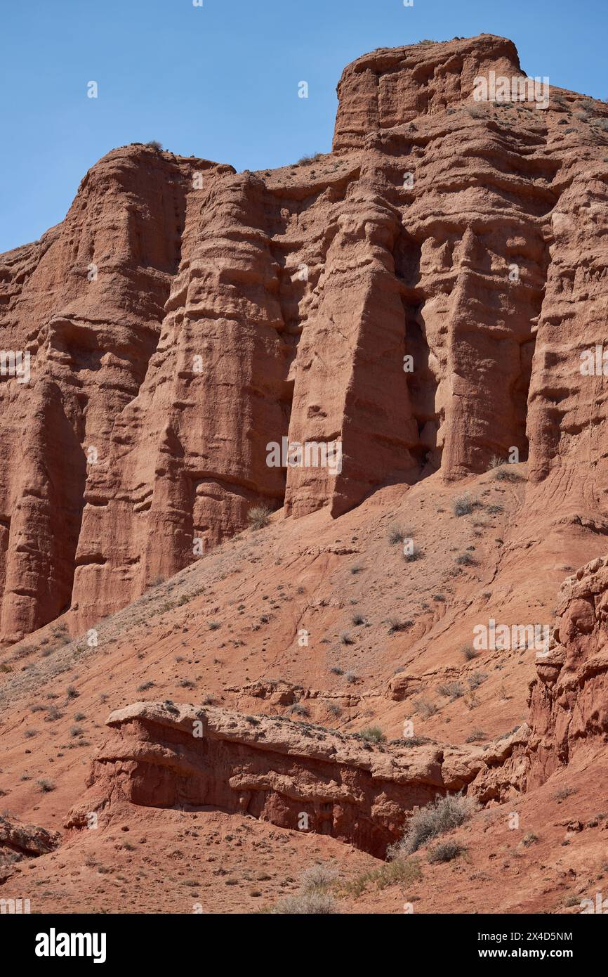 Colonne rocciose di arenaria rossa nel canyon di Konorchek, depositi eolici, scogliere a picco causate dall'erosione del suolo. resistenza agli agenti atmosferici e pulizia della formazione di roccia. Destinazione di viaggio, famoso punto di riferimento del Kirghizistan Foto Stock