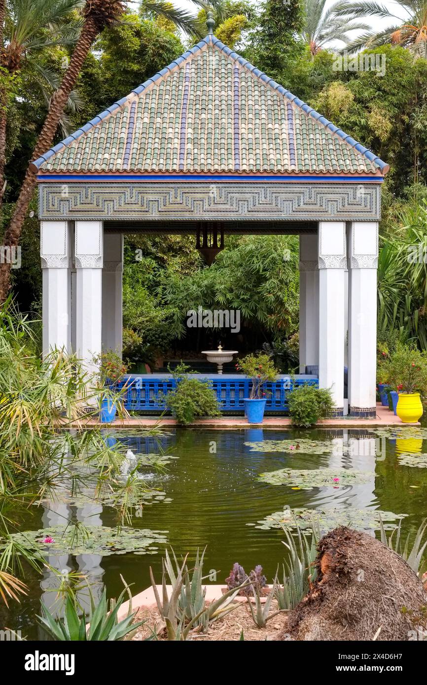 Marrakech, Marocco. Tetto in piastrelle marocchine in cima al gazebo e al tranquillo laghetto. Foto Stock