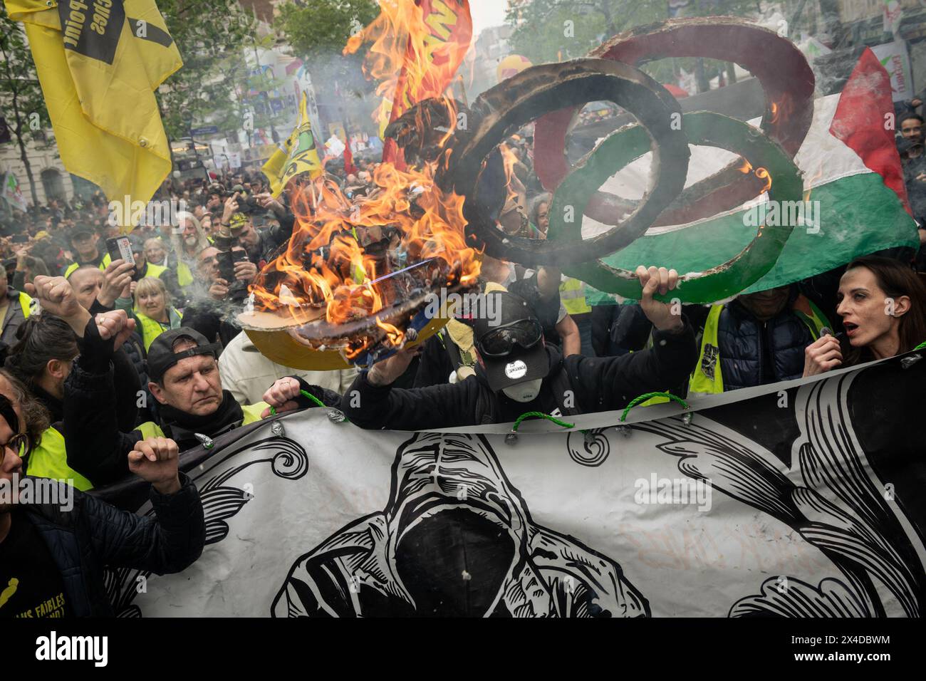 Parigi, Francia. 1° maggio 2024. Un gruppo di manifestanti Gilets Jaunes (gilet gialli) alla testa della marcia del giorno di maggio bruciano un'effigie degli anelli dei Giochi Olimpici. Le proteste annuali del giorno di maggio hanno visto più di 120.000 marzo in tutta la Francia con un grande raduno a Parigi che ha portato a scontri tra manifestanti e polizia antisommossa, con 45 arresti effettuati nella capitale. (Foto di Graham Martin/SOPA Images/Sipa USA) credito: SIPA USA/Alamy Live News Foto Stock