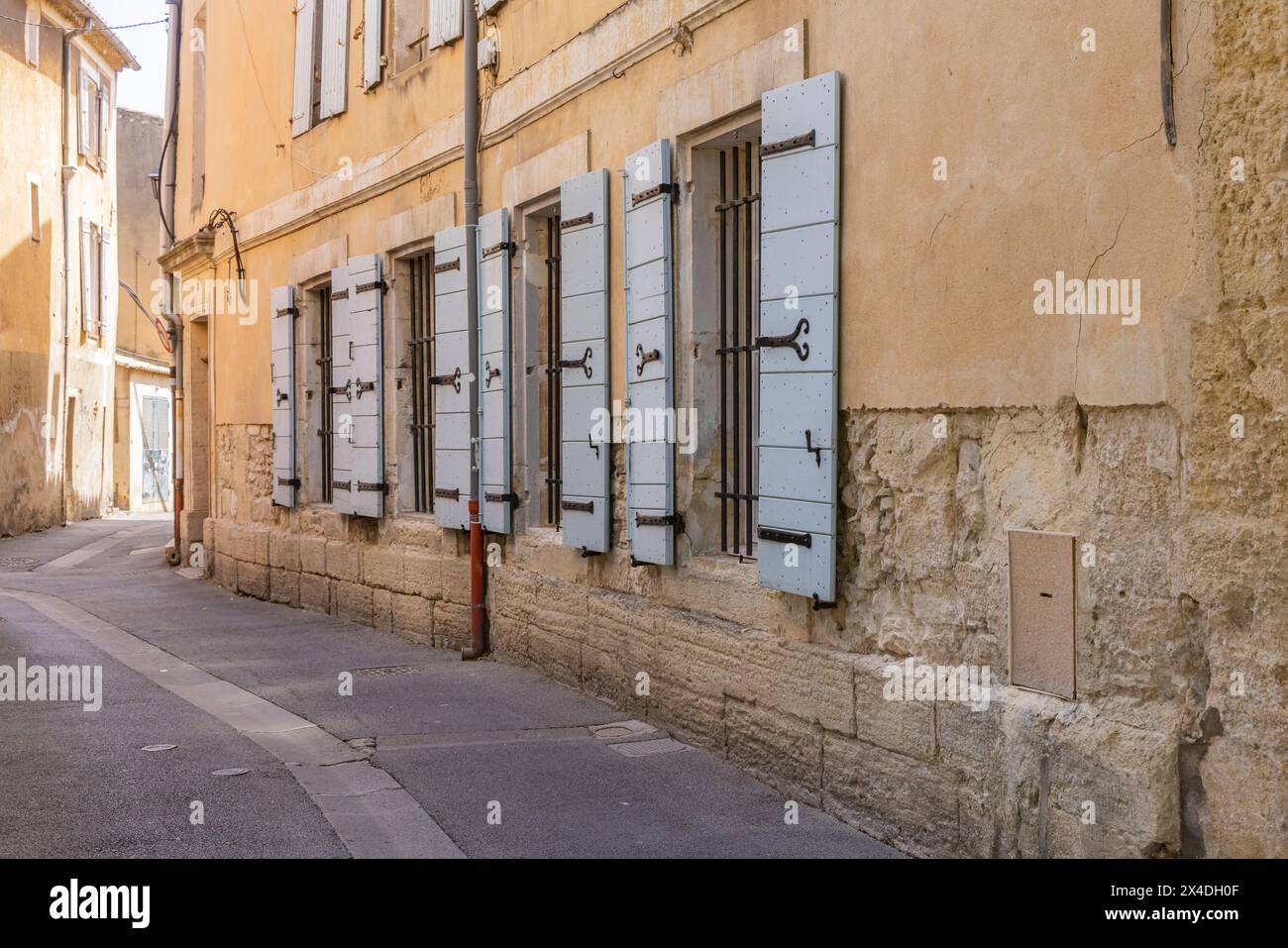 L'Isle-sur-la-Sorgue, Avignone, Vaucluse, Provenza-Alpi-Costa Azzurra, Francia. Finestre con persiane in legno lungo una strada stretta. Foto Stock