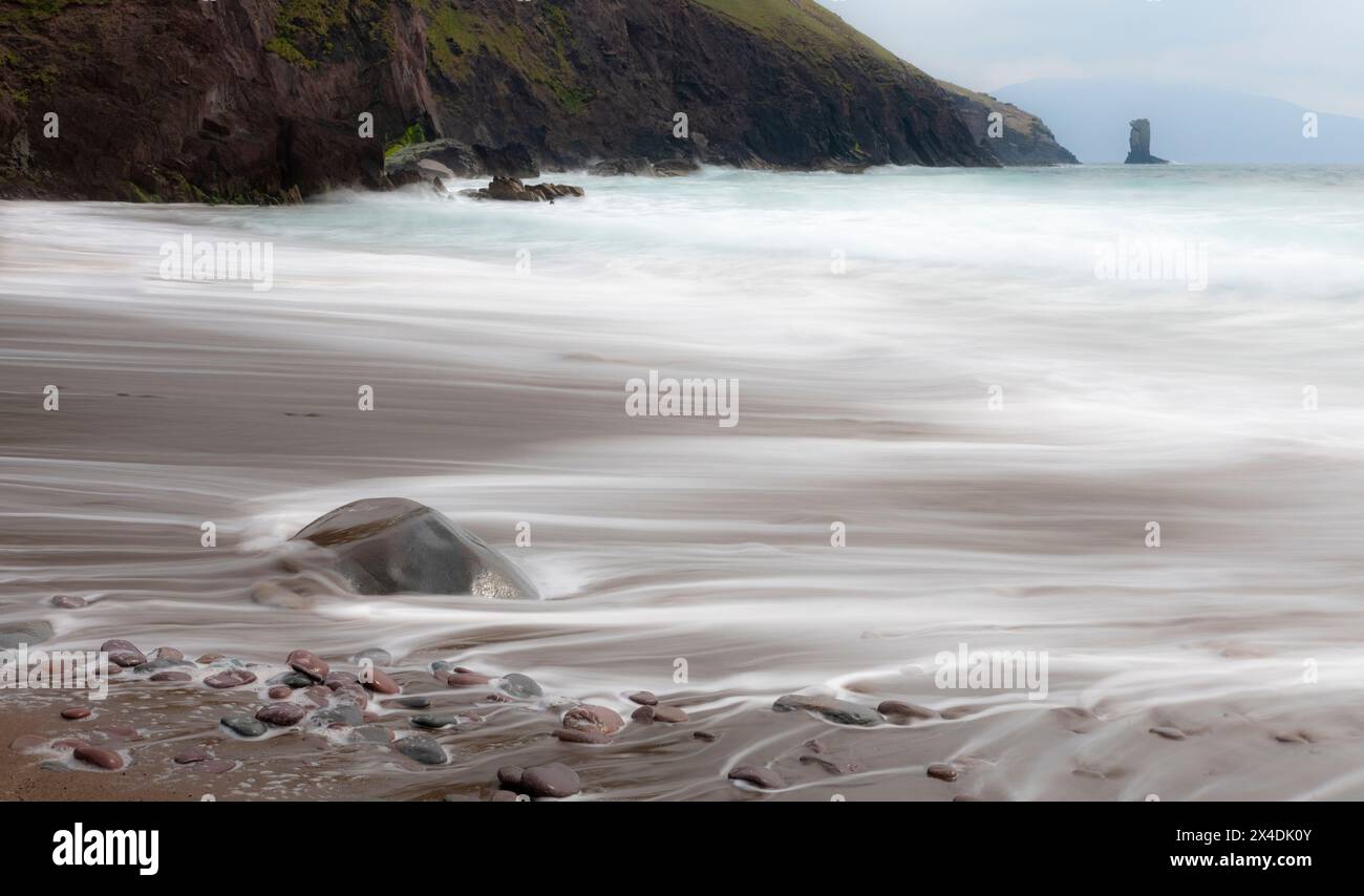 Irlanda, Contea di Kerry, Dunmore Head. Scogliera e onde sull'oceano e sulla spiaggia. Foto Stock