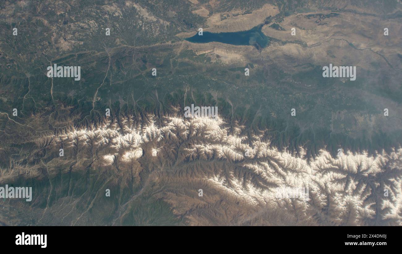 Kutch, Azerbaigian. 25 aprile 2024. Una vista dalla stazione spaziale Internazionale delle montagne innevate del Caucaso che attraversano l'Azerbaigian e la Russia da quasi 258 miglia sopra la superficie terrestre, il 25 aprile 2024, nell'orbita terrestre. In cima, si trova il bacino idrico Mingachevir, il più grande bacino idrico del Caucaso e utilizzato per la pesca, l'approvvigionamento idrico e l'irrigazione. Credito: Astronaut provided/NASA Photo/Alamy Live News Foto Stock