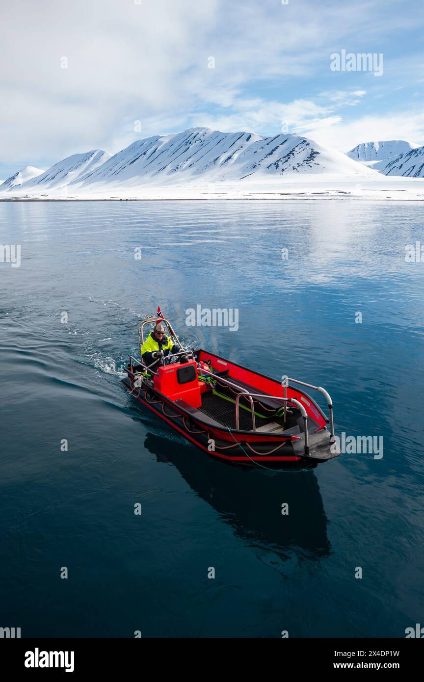 Una zattera gonfiabile naviga nella baia di Mushamna circondata da montagne. Isola di Spitsbergen, Svalbard, Norvegia. (Solo per uso editoriale) Foto Stock