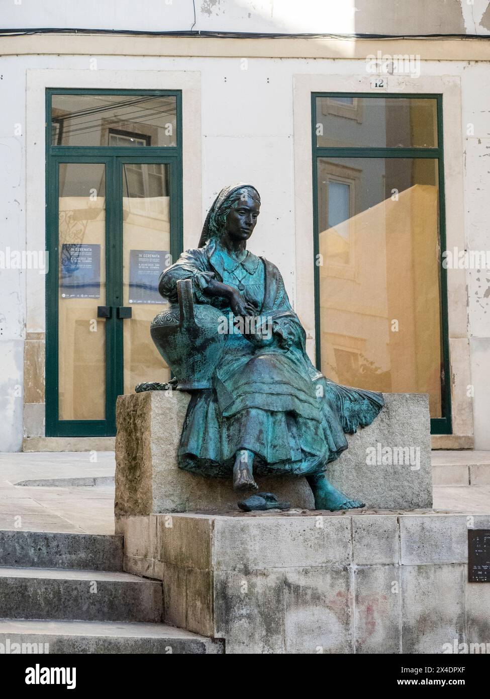 Statua in bronzo di una donna vestita in tradizionale costume portoghese a Rua do Quebra-Costas nel centro storico di Coimbra. Foto Stock