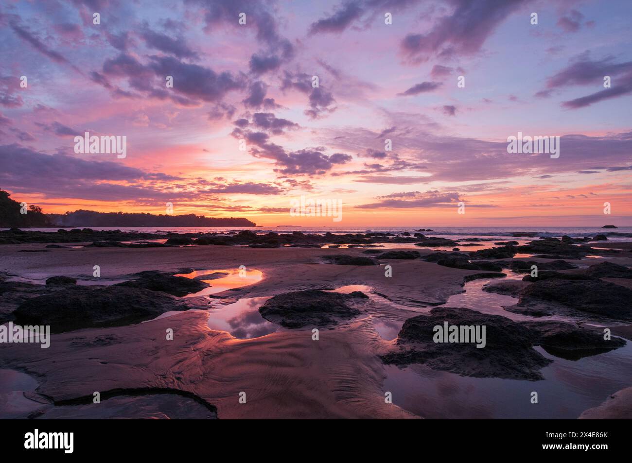 Pozzanghere d'acqua e mucchi di sabbia su una spiaggia al tramonto. Drake Bay, penisola di Osa, Costa Rica. Foto Stock