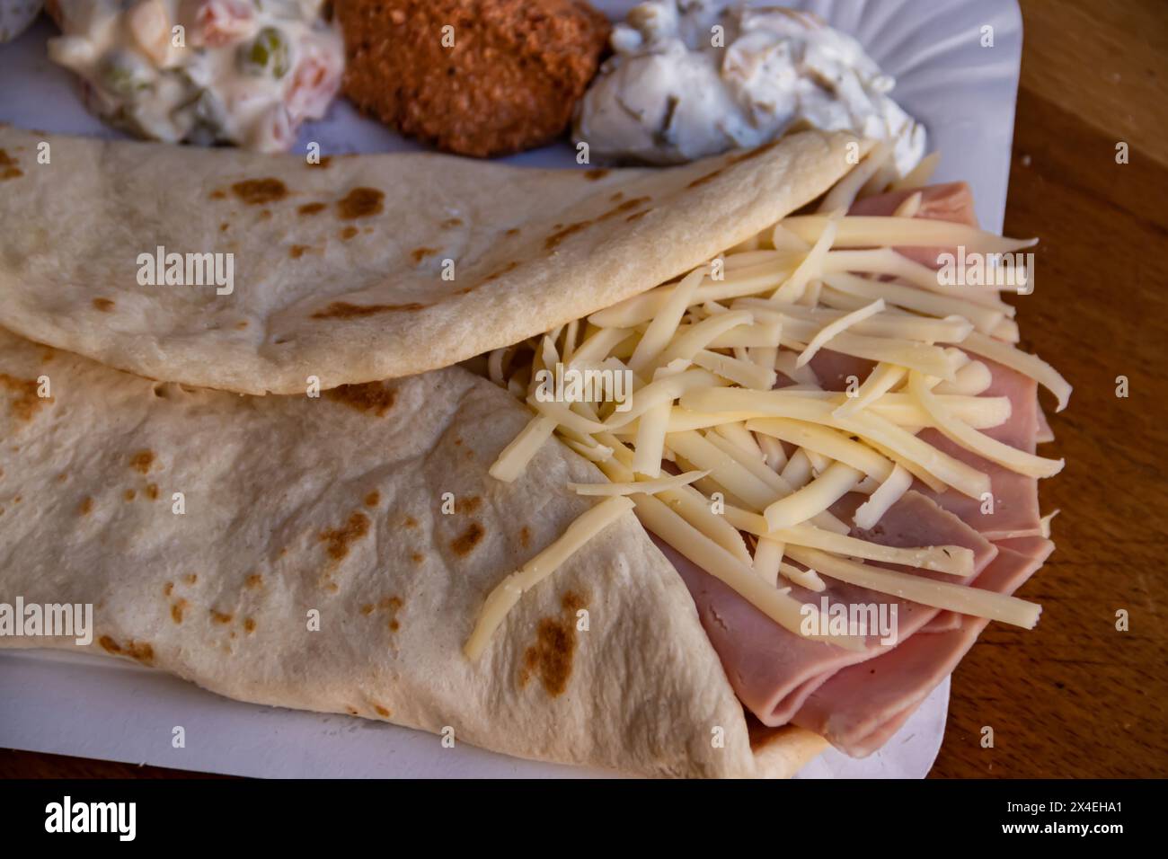 Un gustoso pancake dorato ripieno di prosciutto e formaggio fuso offre una deliziosa combinazione di sapori. Foto Stock