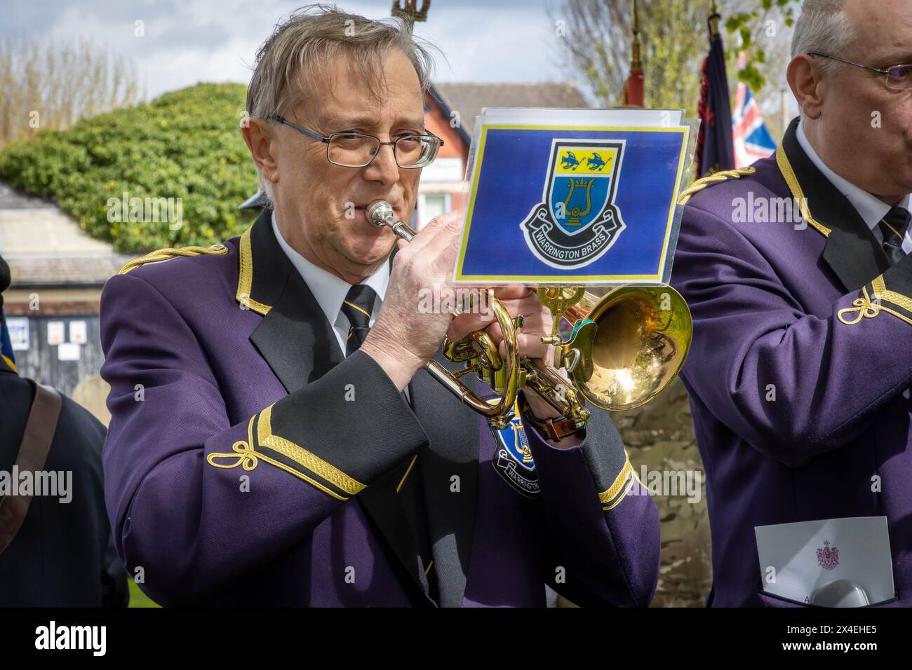 Kelvin Dean della Warrington Brass Band suona The Last Post e Reveille all'ANZAK Day 2024 al cimitero di Warrington il 28 aprile Foto Stock