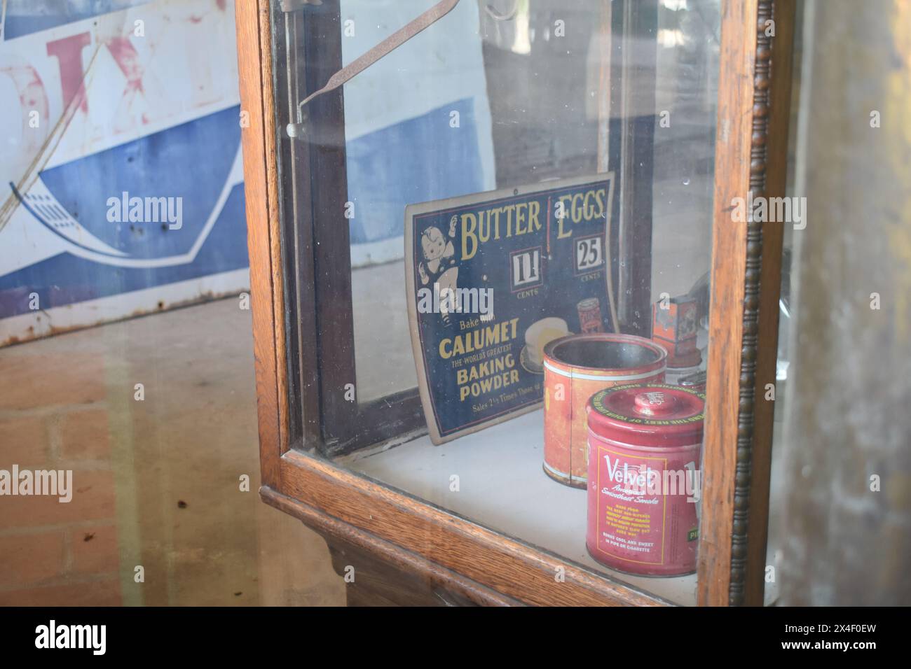 Spencer, Missouri, Stati Uniti - 4.13.24. Guardando attraverso la finestra del vecchio negozio Feed and Seed, ci vengono mostrati i prodotti e i prezzi di un'epoca passata. Foto Stock