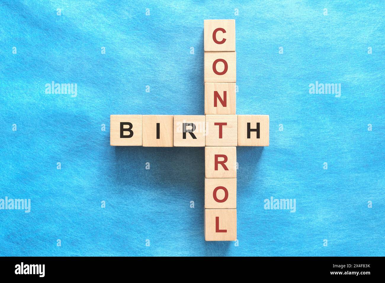 Concetto di controllo delle nascite. Piatto del puzzle con parole incrociate su sfondo blu. Foto Stock