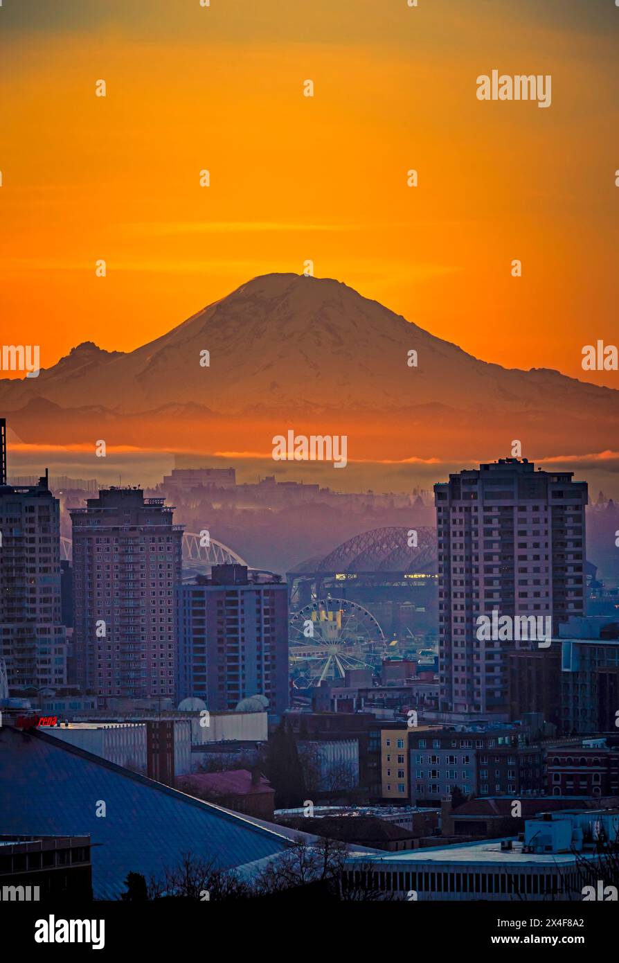 Stati Uniti, Stato di Washington, Seattle. Alba sullo skyline di Seattle da un parco sulla collina di Queen Anne con il monte Rainier sullo sfondo. Foto Stock