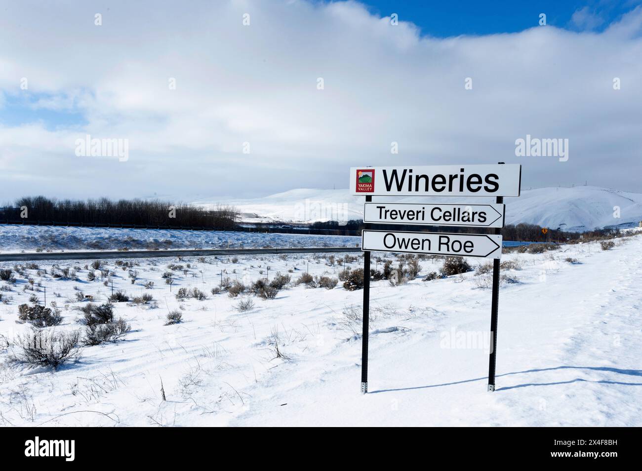 Stati Uniti, Stato di Washington, Yakima Valley. Cartello stradale che indica due aziende vinicole nella Yakima Valley nella neve. (Solo per uso editoriale) Foto Stock