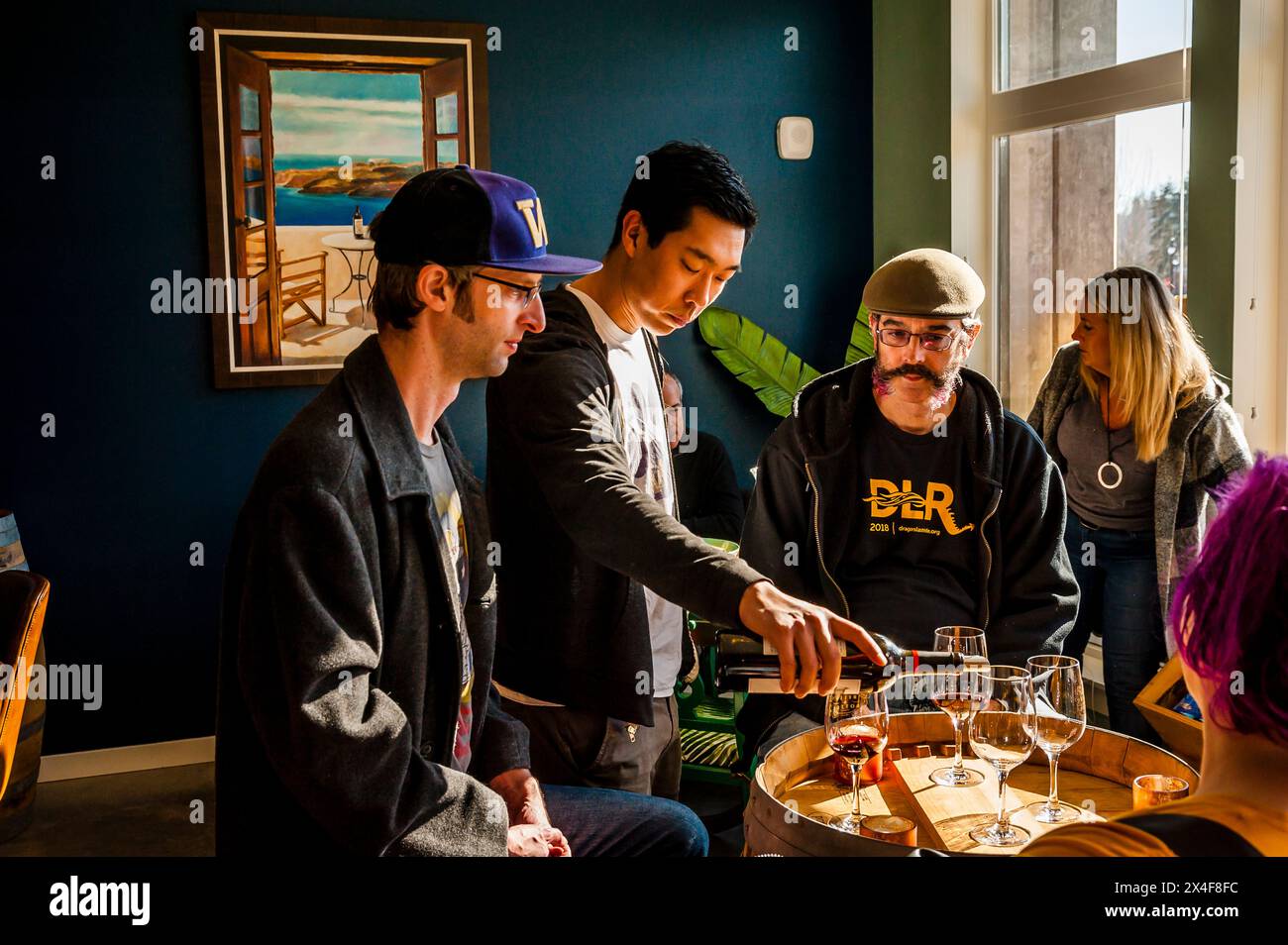 Stati Uniti, Stato di Washington, Bothell. Belle e bottiglia. Will Camarda, enologo della cantina Andrew Will, versa vino rosso durante una degustazione. (Solo per uso editoriale) Foto Stock