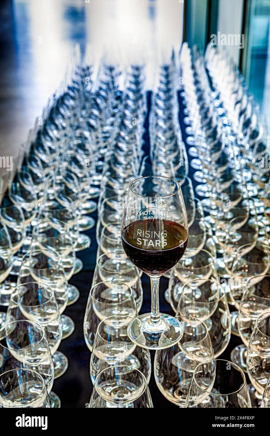 Stati Uniti, Stato di Washington, Prosser. File di bicchieri da vino accompagnano un bicchiere di vino rosso Rising Star. (Solo per uso editoriale) Foto Stock