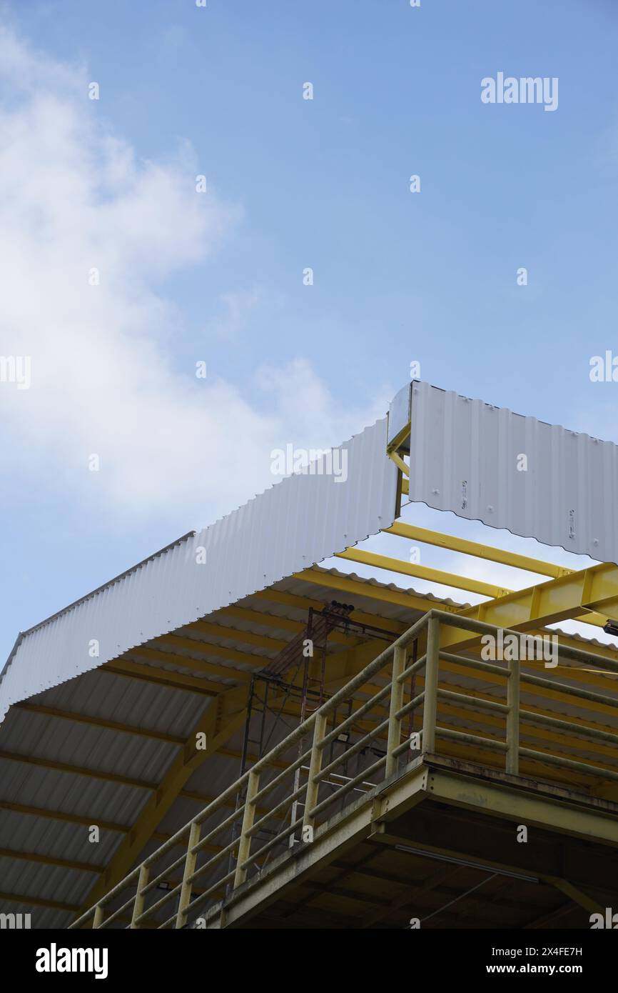 Edificio aperto di colore giallo realizzato con tetto in ferro e amianto con cielo limpido al mattino Foto Stock