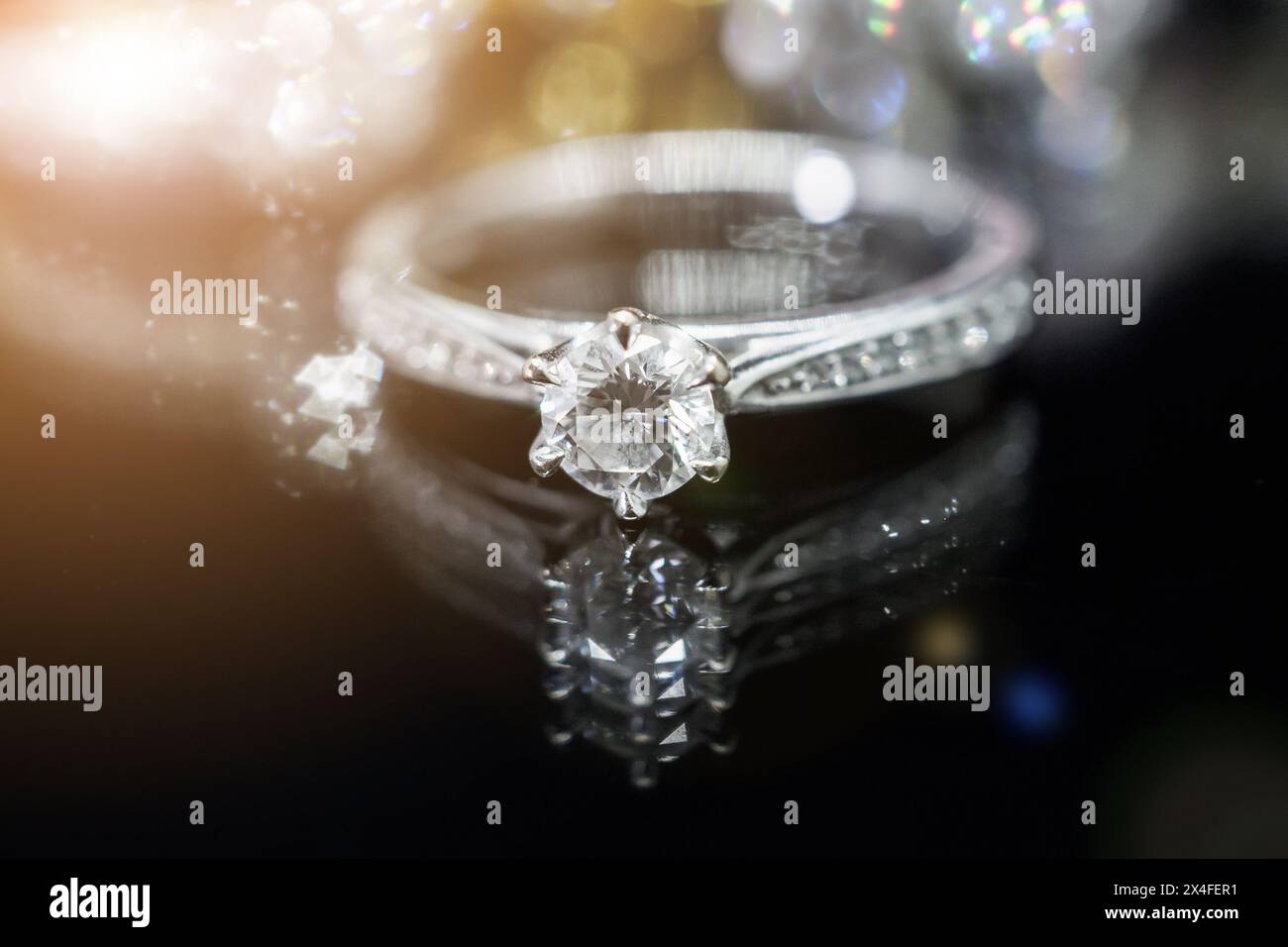 Anelli diamantati Luxury Jewelry con riflessi su sfondo nero Foto Stock