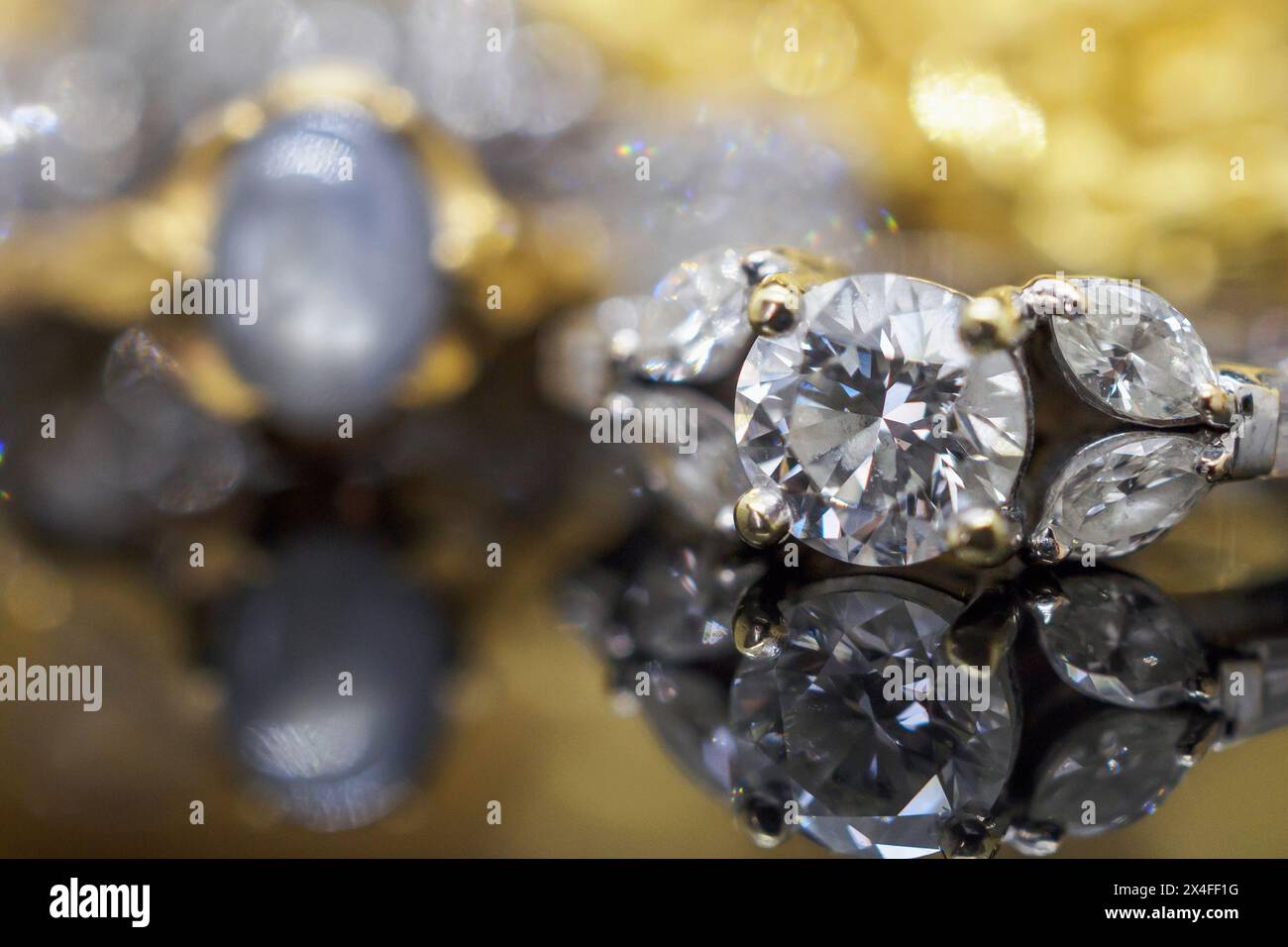 Gioielli in oro di lusso con anelli in diamante con riflesso su sfondo nero Foto Stock
