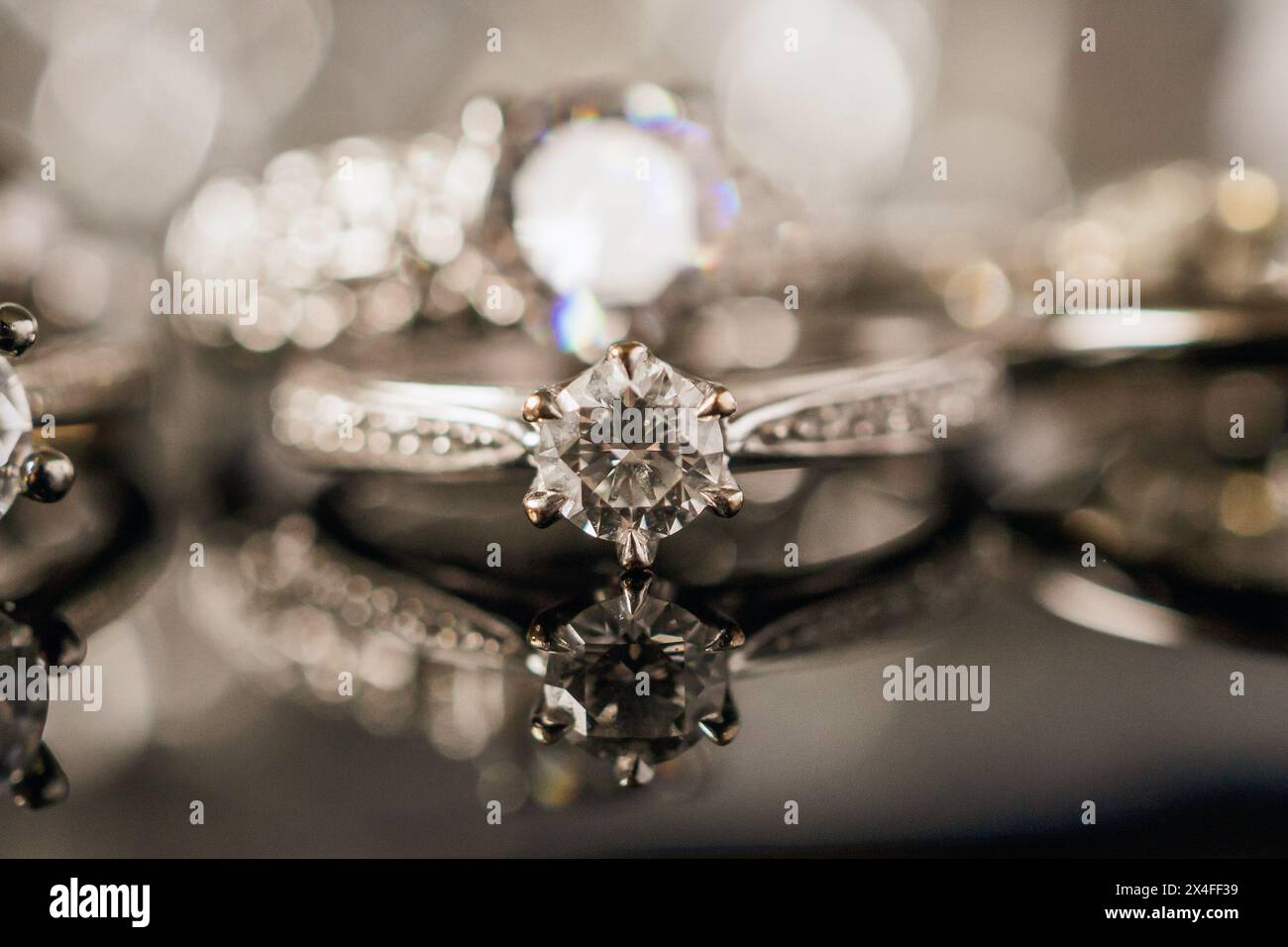 Anelli diamantati Luxury Jewelry con riflessi su sfondo nero Foto Stock