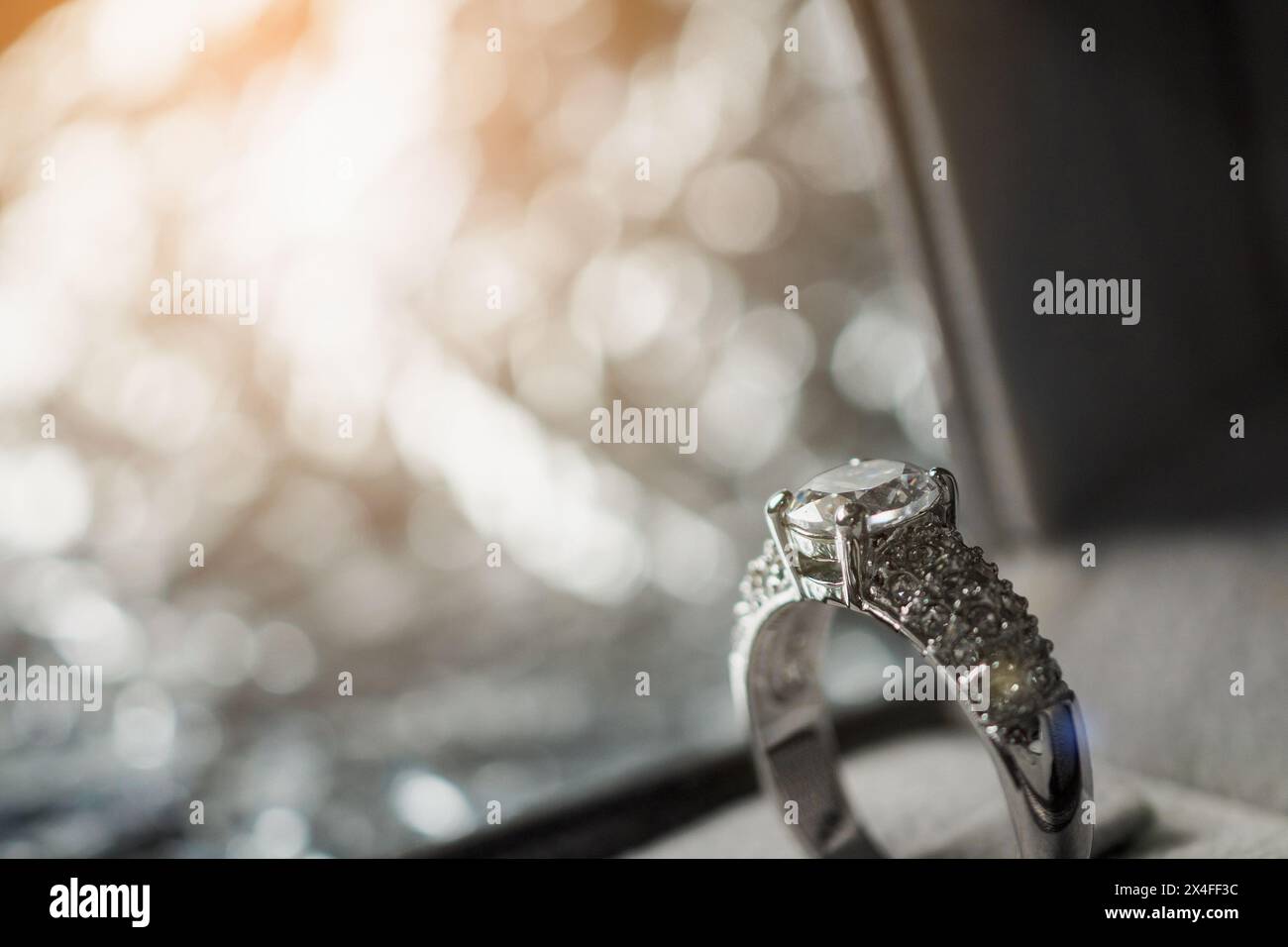 Anello Diamond engagement di lusso in una confezione regalo di gioielli con sfondo chiaro bokeh Foto Stock