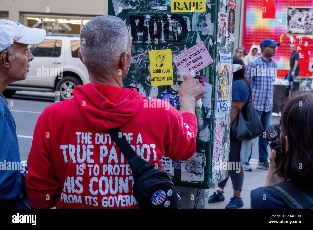 New York, Stati Uniti. 2 maggio 2024. Un uomo mette degli adesivi su una scatola elettrica in strada. Uno dice "frenate il vostro antisemitismo” e l'altro dice "gli studenti ebrei non stanno andando da nessuna parte” le tensioni aumentano mentre i manifestanti pro-palestinesi alla New School di New York si incontrano con i contro-manifestanti pro-Israele. L'organizzazione New School Students for Justice in Palestine ha istituito un accampamento all'interno dell'edificio della scuola 11 giorni fa, chiedendo alla scuola di rivelare e cedere qualsiasi legame finanziario con Israele. (Foto di Syndi Pilar/SOPA Images/Sipa USA) credito: SIPA USA/Alamy Live News Foto Stock