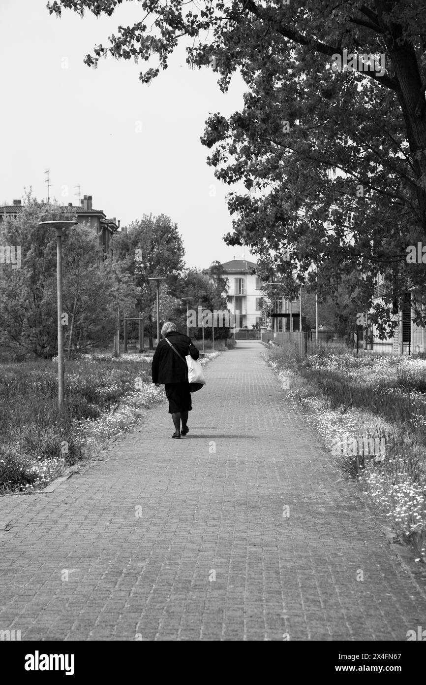 Donna anziana che cammina da sola nel parco Foto Stock