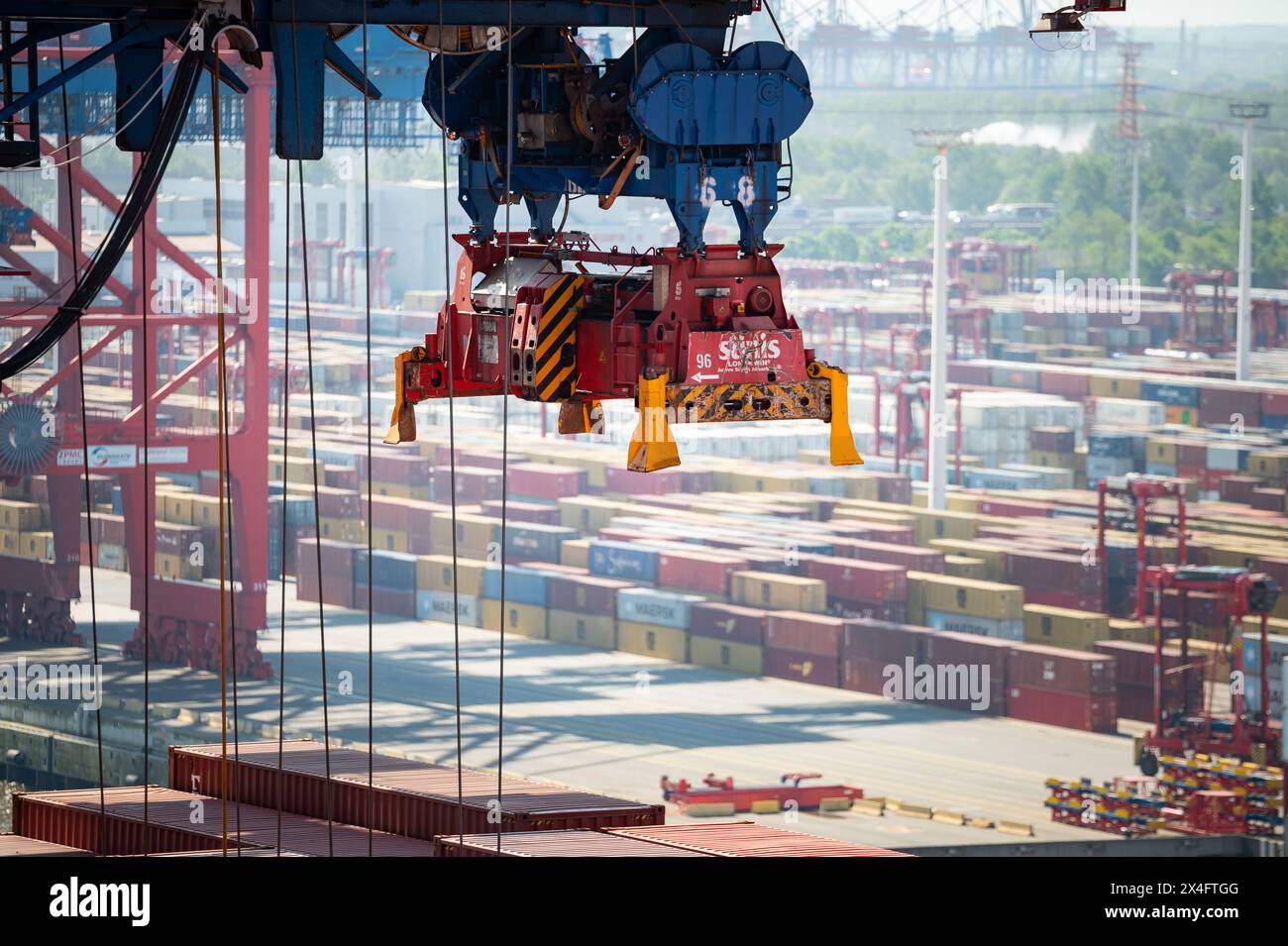 Amburgo, Germania. 2 maggio 2024. Una gru a cavalletto per container si trova sopra una nave di fronte a numerosi container parcheggiati presso il terminal Eurogate. Crediti: Jonas Walzberg/dpa/Alamy Live News Foto Stock