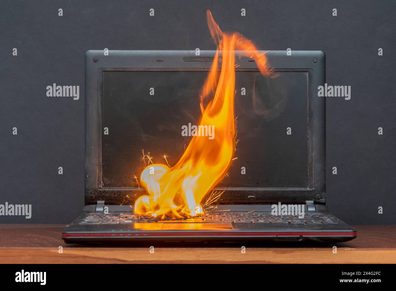 Nella stanza sul tavolo il computer portatile ha preso fuoco, l'accensione della batteria e dei contatti, un cortocircuito. Sistema antincendio. Foto Stock