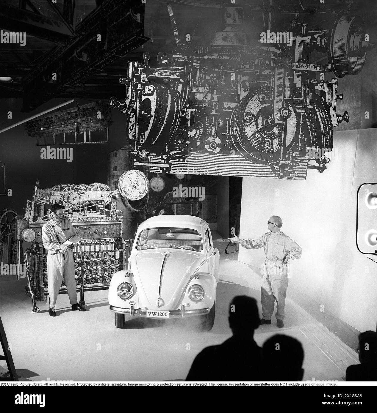 Volkswagen tipo 1. Modello di auto d'epoca della casa automobilistica tedesca Volkswagen. Fu costruito dalla Volkswagenwerk in Germania. Al modello di auto sono stati assegnati dei soprannomi. Era chiamato "Käfer" in tedesco e "Beetle" in inglese. L'iconica vettura è stata prodotta tra il 1938 e il 2003 con una produzione totale di oltre 21,5 milioni di auto. Un'immagine tratta dalle riprese di un film pubblicitario del 1963 con la VW 1200 in primo piano in un'avvincente meccanica. Kristoffersson rif. DC79-12 Foto Stock