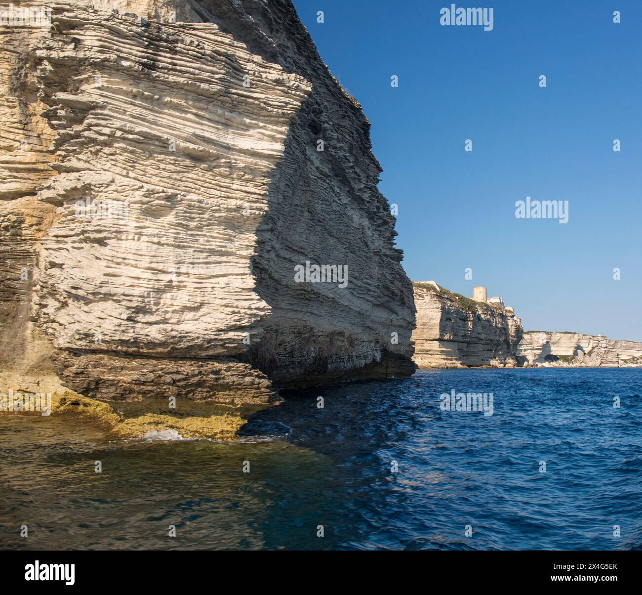 Bonifacio, Corse-du-Sud, Corsica, Francia. Vista dall'angolo basso dal mare delle aspre scogliere calcaree di Pointe du Timon. Foto Stock
