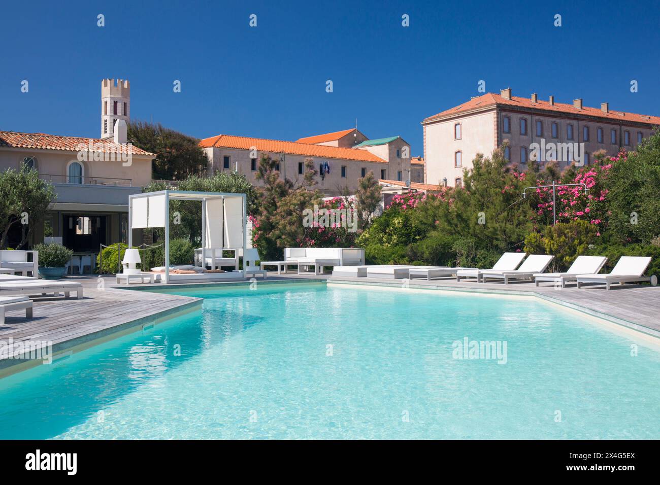 Bonifacio, Corse-du-Sud, Corsica, Francia. Vista sulla piscina dell'Hôtel Genovese, torre dell'Église Saint-Dominique visibile sullo sfondo. Foto Stock
