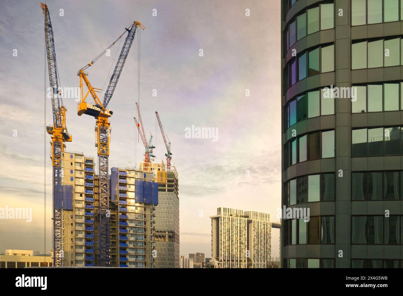 Lavori di costruzione di alti edifici circondati da gru a torre nel quartiere centrale degli affari del centro di Singapore Foto Stock