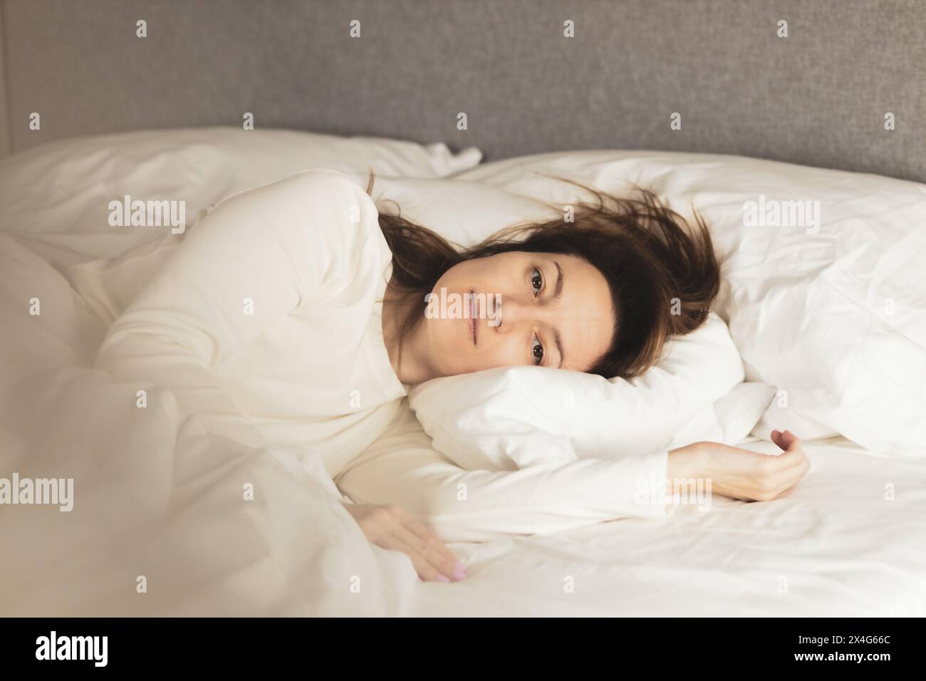 Ritratto di giovane donna sdraiata sul letto Foto Stock