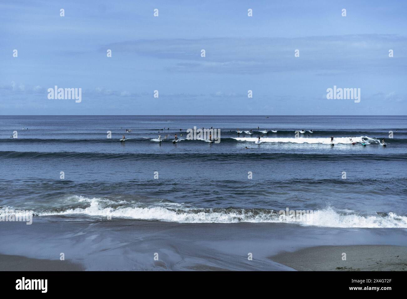 Molti surfisti catturano le onde nell'oceano, Bali Foto Stock