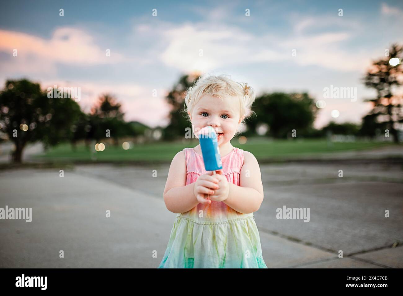 Il bambino adorabile si diverte con un gelato al tramonto Foto Stock