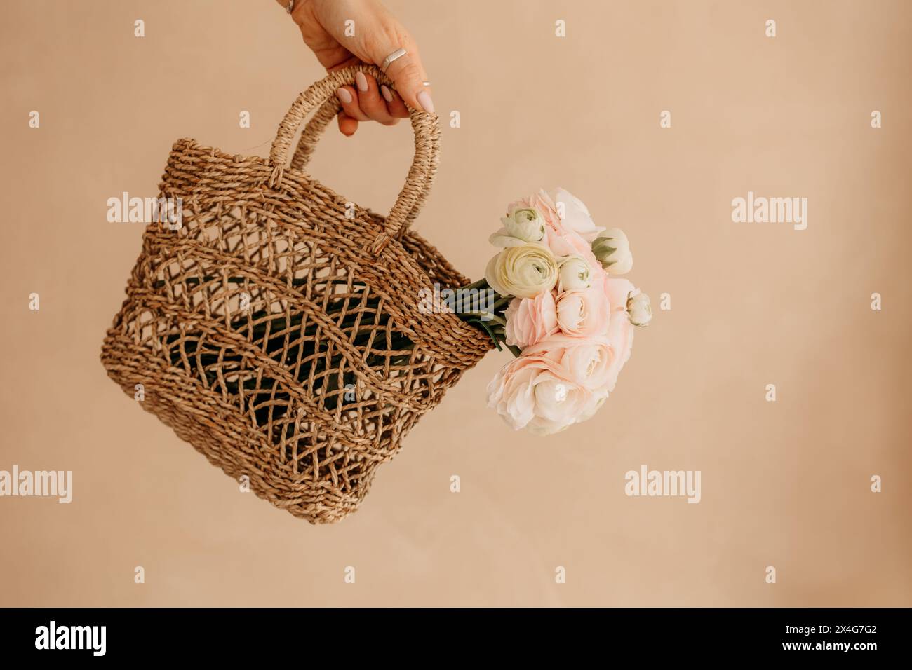 Fiori rosa e bianchi in un cestino accogliente Foto Stock